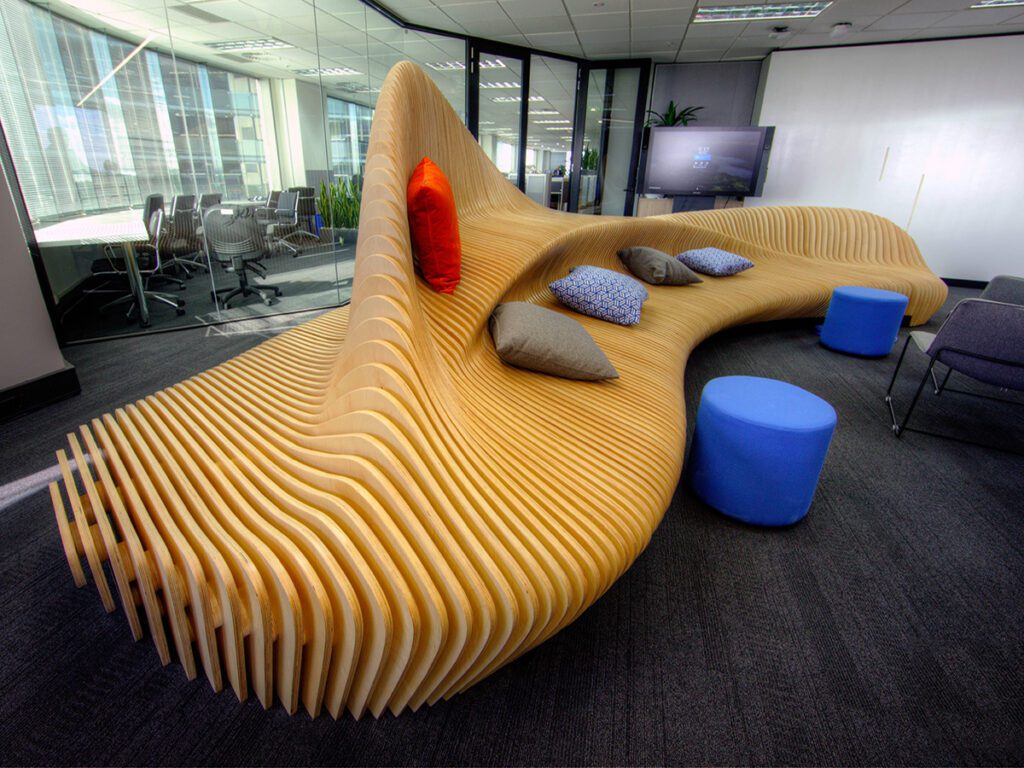 Sleek and modern office interior featuring a sculptural wooden bench with a flowing design, creating a focal point in the room and encouraging collaboration.