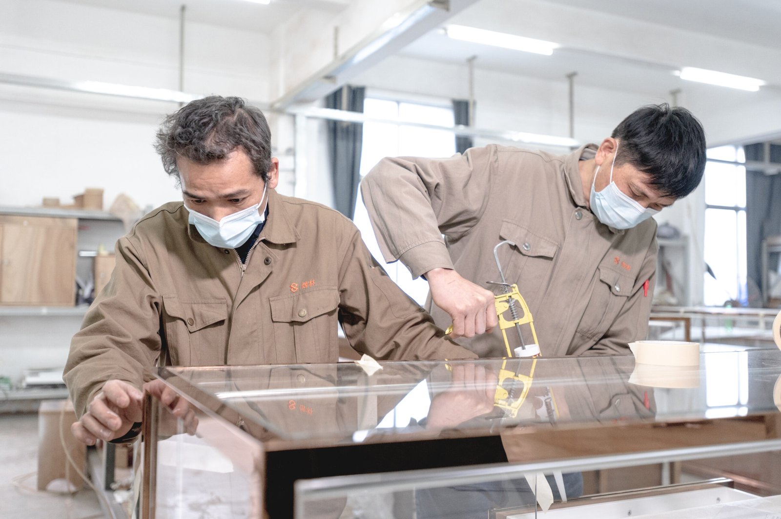 Two employees collaboratively installing retail showcases, demonstrating expertise and precision in shop fitting services.