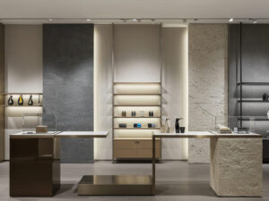 A high-end retail store interior showcasing a variety of display fixtures. The image should emphasize the contrast between different materials—such as glossy metal, natural wood, frosted glass, and textured stone—used in shelving, product stands, and backdrops. Lighting should highlight how these materials guide customer attention across the display area. The atmosphere should be modern and elegant, reflecting a premium shopping experience.
