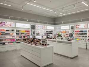 Modern beauty store with tester area, open shelves, and luxury counters under elegant lighting.